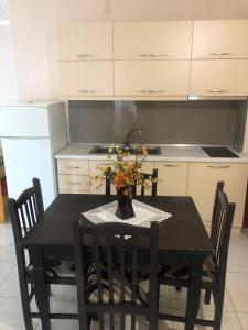 a kitchen with a table with a vase of flowers on it at Pogradec Lakefront Apartment in Pogradec