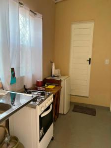 a kitchen with a stove and a white door at Pousada Amiga in Parintins