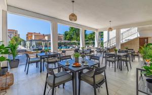 a restaurant with tables and chairs and large windows at Lotus Resort B&B in Pula