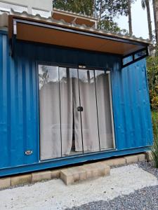 a blue tiny house with a large window at Flat Container 3 Km do Centro de Brusque para até 4 pessoas in Brusque