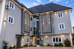 a white house with a black roof at Smarthome Hotel in Benin City