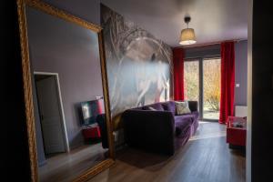 a living room with a purple couch and a mirror at L'Avant-Première Chic 40m2 with Parking in Évreux