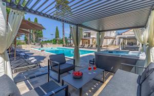 a patio with a pool and a table and chairs at Lotus Resort B&B in Pula