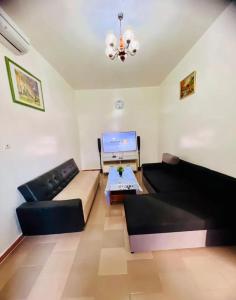 a living room with a couch and a table at Charming apartment in M'bour + 100 m² + pool in Mbour