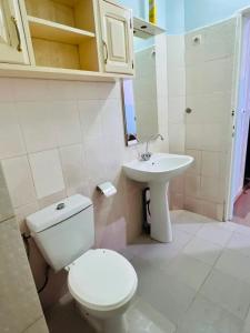 a bathroom with a toilet and a sink at Charming apartment in M'bour + 100 m² + pool in Mbour