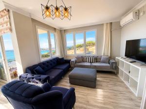 a living room with blue couches and a television at Ada Hill Ayvalık in Ayvalık