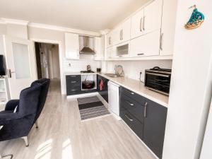 a kitchen with white cabinets and black appliances at Ada Hill Ayvalık in Ayvalık +9 photos