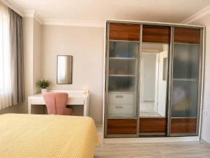 a bedroom with a glass closet and a desk at Ada Hill Ayvalık in Ayvalık