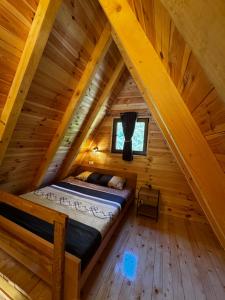 a bed in the attic of a log cabin at Villa Komarnica Hideaway in Šavnik