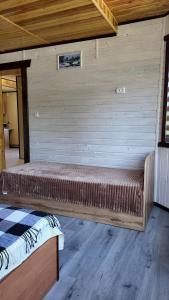 a bed in a room with a wooden wall at Оксана та Назар in Mykulychyn