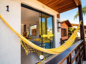 a hammock on the balcony of a house at Lugar ao Sol - Flats c/ Cozinha no Rosa in Praia do Rosa