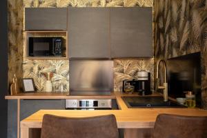 a kitchen with a counter with a stove and a microwave at L'Avant-Première Chic 40m2 with Parking in Évreux