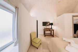 a bedroom with a bed and a chair and a window at Nobile Dimora di Puglia in Ostuni