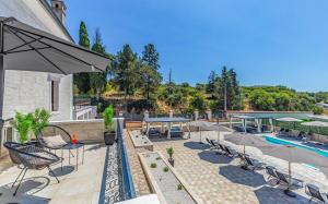an outdoor patio with a pool and tables and chairs at Lotus Resort B&B in Pula
