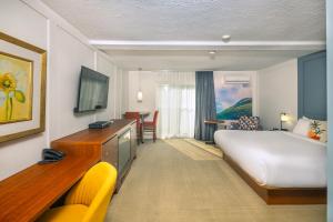 a hotel room with a large bed and a desk at Clarion Pointe La Malbaie in La Malbaie