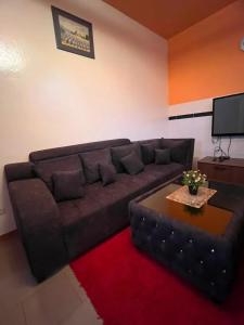 a living room with a brown couch and a table at Spacious Apartment with Pool in M'bour - 100 m² in Mbour