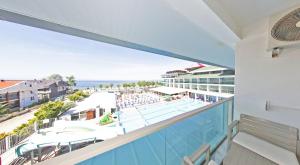 a view of the pool and beach from the balcony of a resort at Ceti̇n Presti̇ge Resort in Erdek
