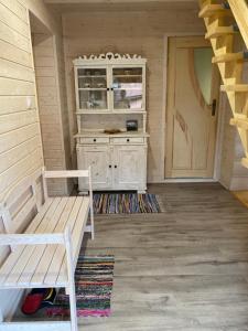 a room with a bench and a cabinet and a door at Leśny Zakątek in Glinka