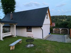 a house with a bench and a picnic table in the yard at Leśny Zakątek in Glinka