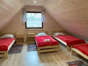 a room with two beds and a window at Leśny Zakątek in Glinka