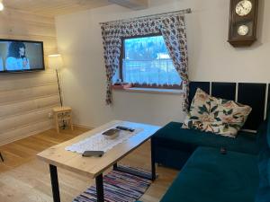 a living room with a couch and a table at Leśny Zakątek in Glinka