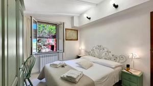 a white bedroom with a bed and a window at Villa Mica in La Maddalena