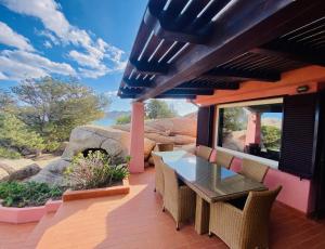 a patio with a table and chairs on a deck at Villa Mica in La Maddalena