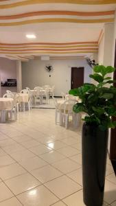 a room with white tables and chairs and a plant at Hotel Eldorado de Salinas in Salinas
