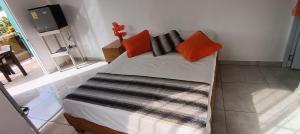 a bed with orange and black pillows in a room at Puravida # 1 in Colorado