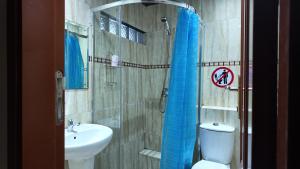 a bathroom with a sink and a toilet and a shower at The Quiet Corner Guest House in Maputo +17 photos