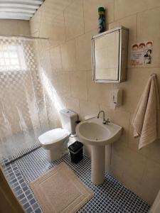 a bathroom with a toilet and a sink at Edícula 1 em São Pedro in São Pedro