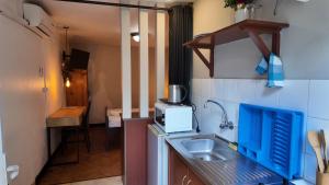 a small kitchen with a sink and a microwave at The Quiet Corner Guest House in Maputo