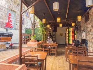 a restaurant with wooden tables and wooden chairs at Tarihi Rum Konağı Antikhan in Ayvalık