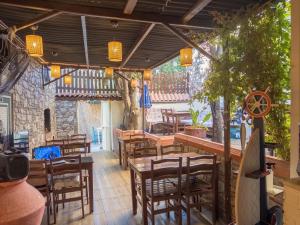 a restaurant with wooden tables and chairs in a room at Tarihi Rum Konağı Antikhan in Ayvalık