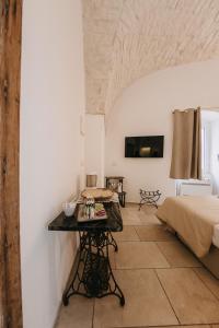 a bedroom with a bed and a table in a room at Nobile Dimora di Puglia in Ostuni