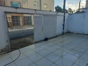 an empty patio with a white fence and a gate at Machado Monteiro in Guarapari