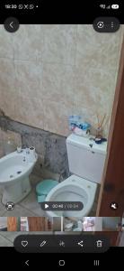 a bathroom with a toilet and a sink at Francolini dptos in La Banda