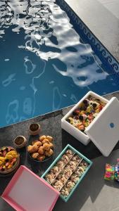 a table topped with boxes of food next to a pool at حكاية سما in Āsam +8 photos