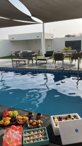 a pool with food on the ground next to a table at حكاية سما in Āsam