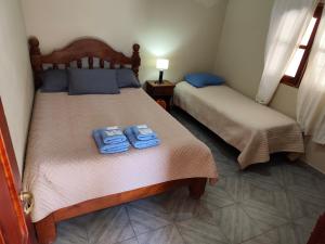 two beds in a room with two towels on them at El Refugio Departamentos in Iruya