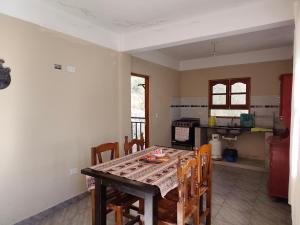 a dining room with a table and chairs in a kitchen at El Refugio Departamentos in Iruya