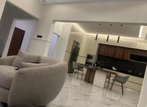 a living room with a couch and a kitchen at Rouge Villa in Winneba