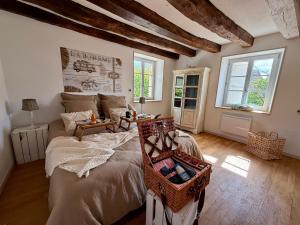 a bedroom with a bed with a basket on it at Le Petit Refuge - La Petite Longère in Rahon