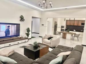 a living room with a couch and a flat screen tv at Rouge Villa in Winneba