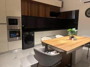 a kitchen with a wooden table and chairs and a stove at Rouge Villa in Winneba +8 photos