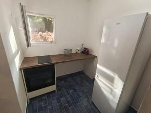 a kitchen with a desk next to a refrigerator at Pergola Garden in Nikšić