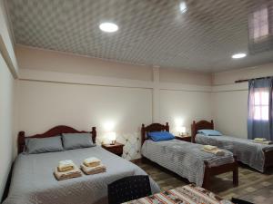 a room with two beds with towels on them at El Refugio Departamentos in Iruya +21 photos