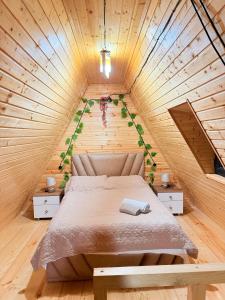 a bedroom with a bed in a wooden house at ჰარმონია Harmony Cottage in Ambrolauri