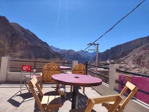 a table and chairs on a balcony with a view of the mountains at El Refugio Departamentos in Iruya