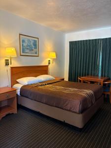 a hotel room with a large bed and two night stands at Motel Garberville in Garberville
